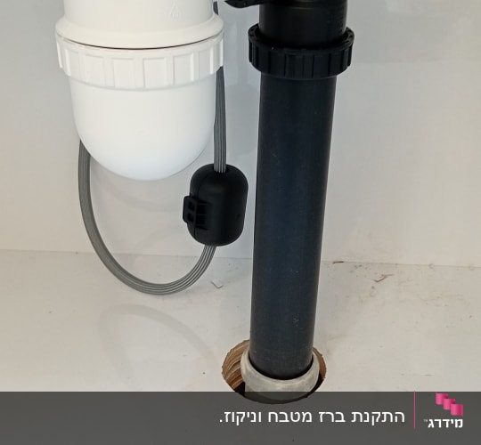 צנרת פלסטיק לבנה ושחורה מתחת לכיור